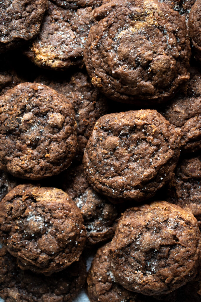Sourdough discard chocolate peanut butter swirl cookies stacked over top of each other and covered in sugar.