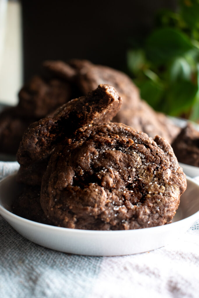 Sourdough discard chocolate peanut butter swirl cookies on a white plate with a green plate in the background.