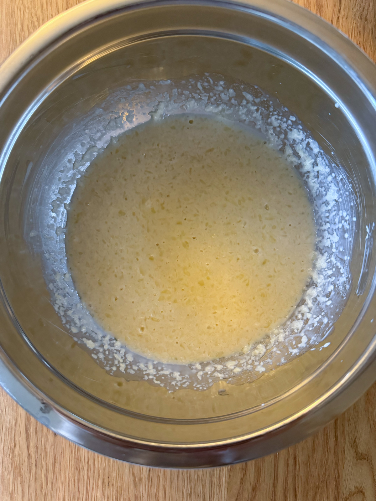 Wet ingredients for oat milk pancake batter in a metal mixing bowl.
