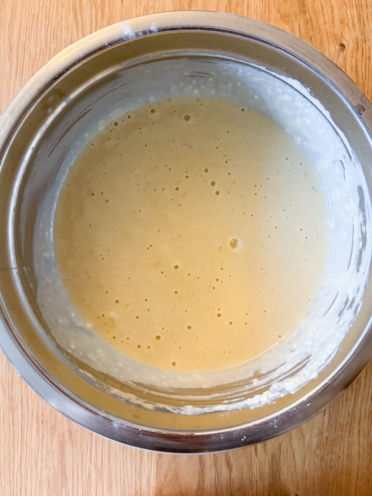 Batter for oat milk pancake batter in a metal mixing bowl.