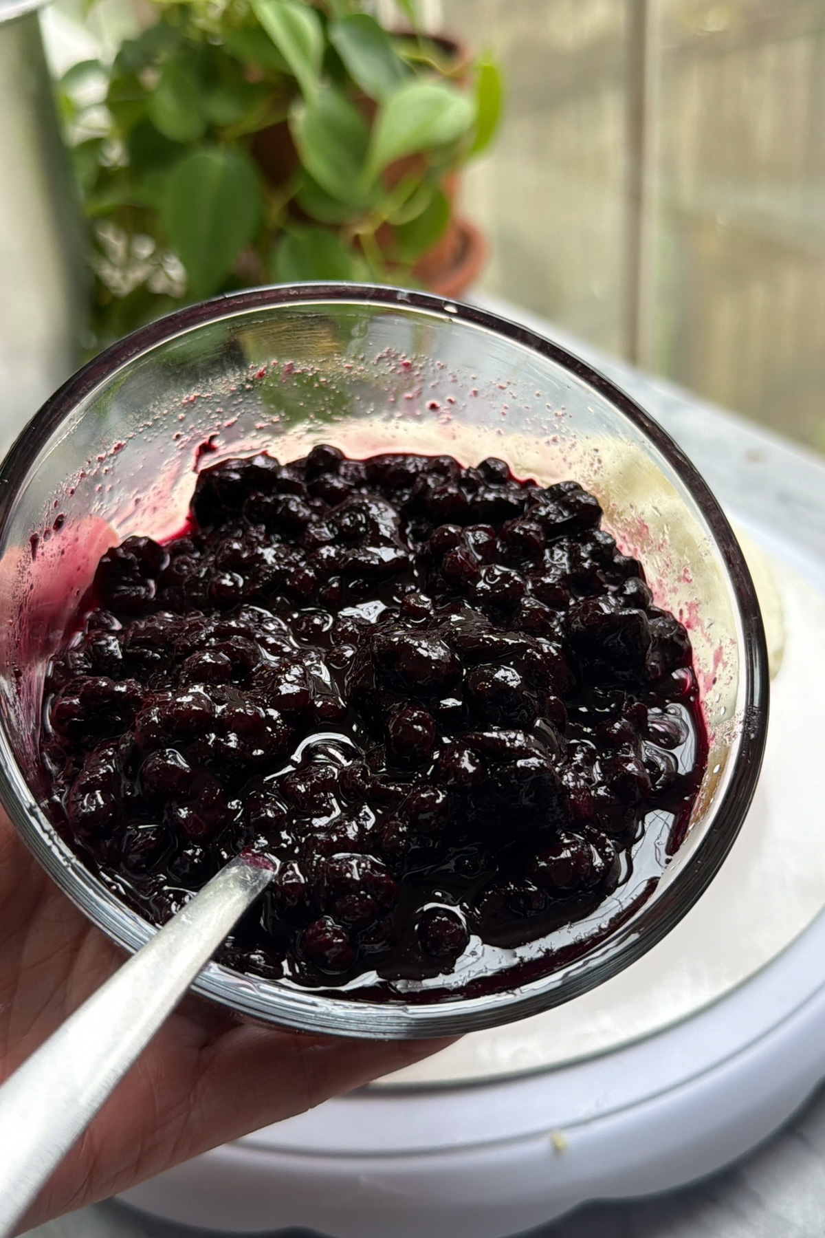 Blueberry compote in a glass bowl before being added to lemon blueberry mascarpone cake.