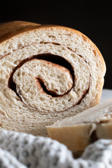 Sourdough discard cinnamon swirl bread cut in half to show the texture and swirl.