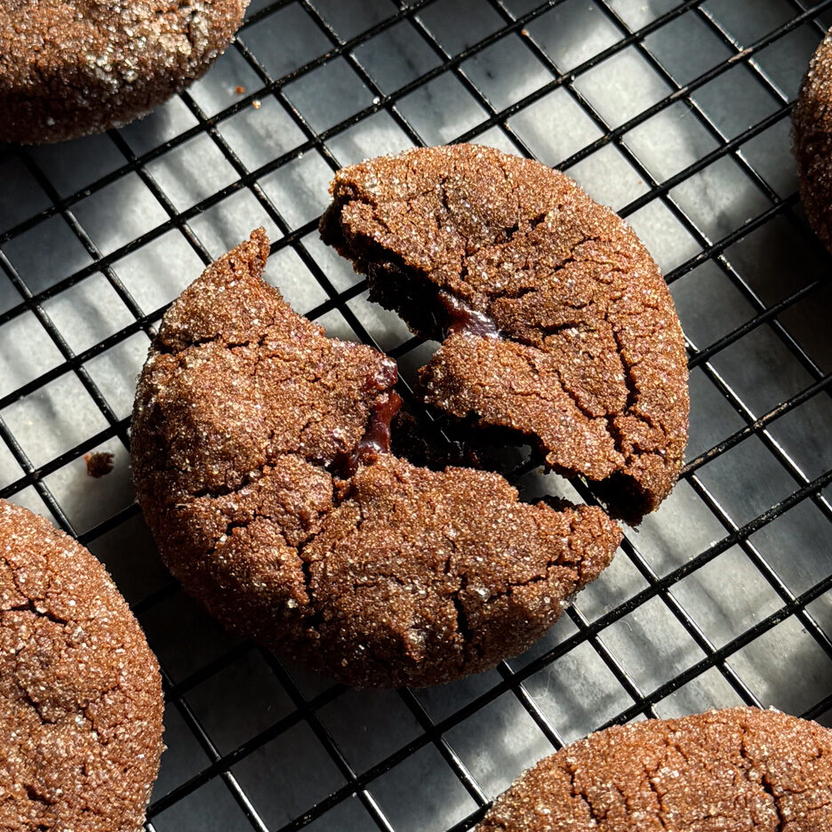 Double chocolate filled cookies on a black metal cooling rack.