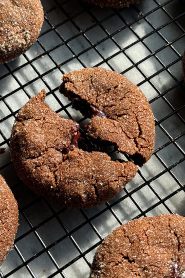 Double chocolate filled cookies on a black metal cooling rack.