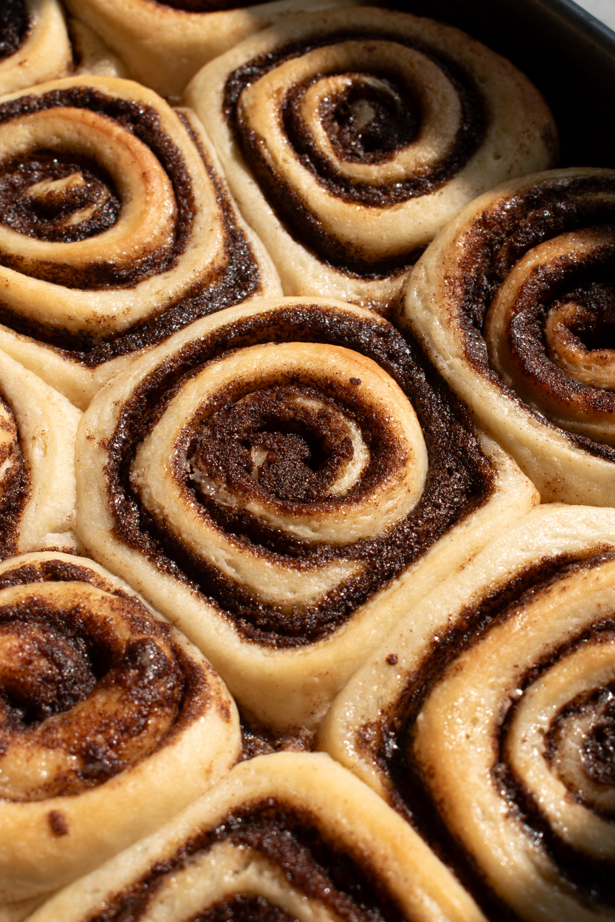 Close up of fluffy, gooey sourdough discard cinnamon rolls before frosting.