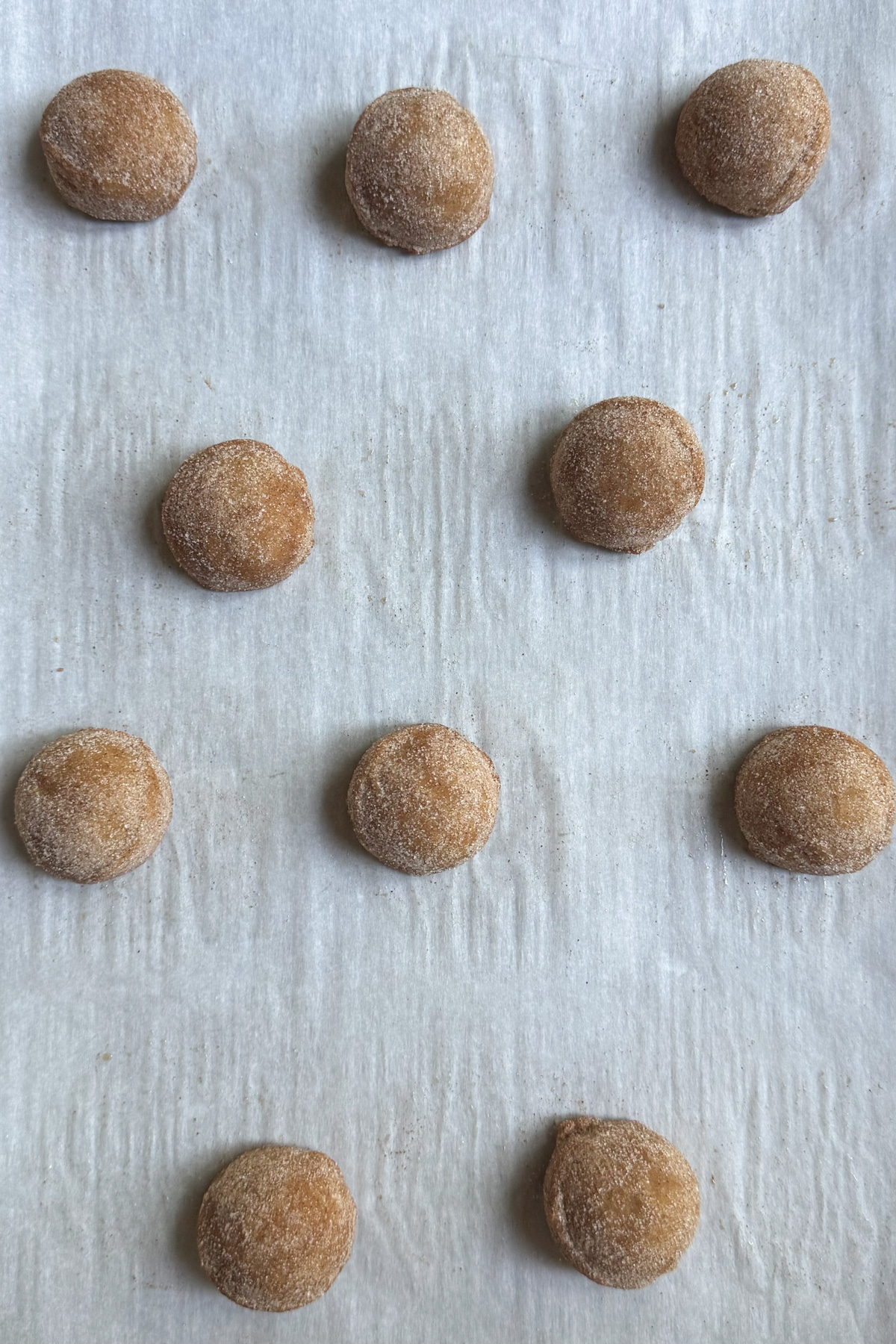 Picture of brown butter snickerdoodle cookie dough balls on a baking sheet before baking.