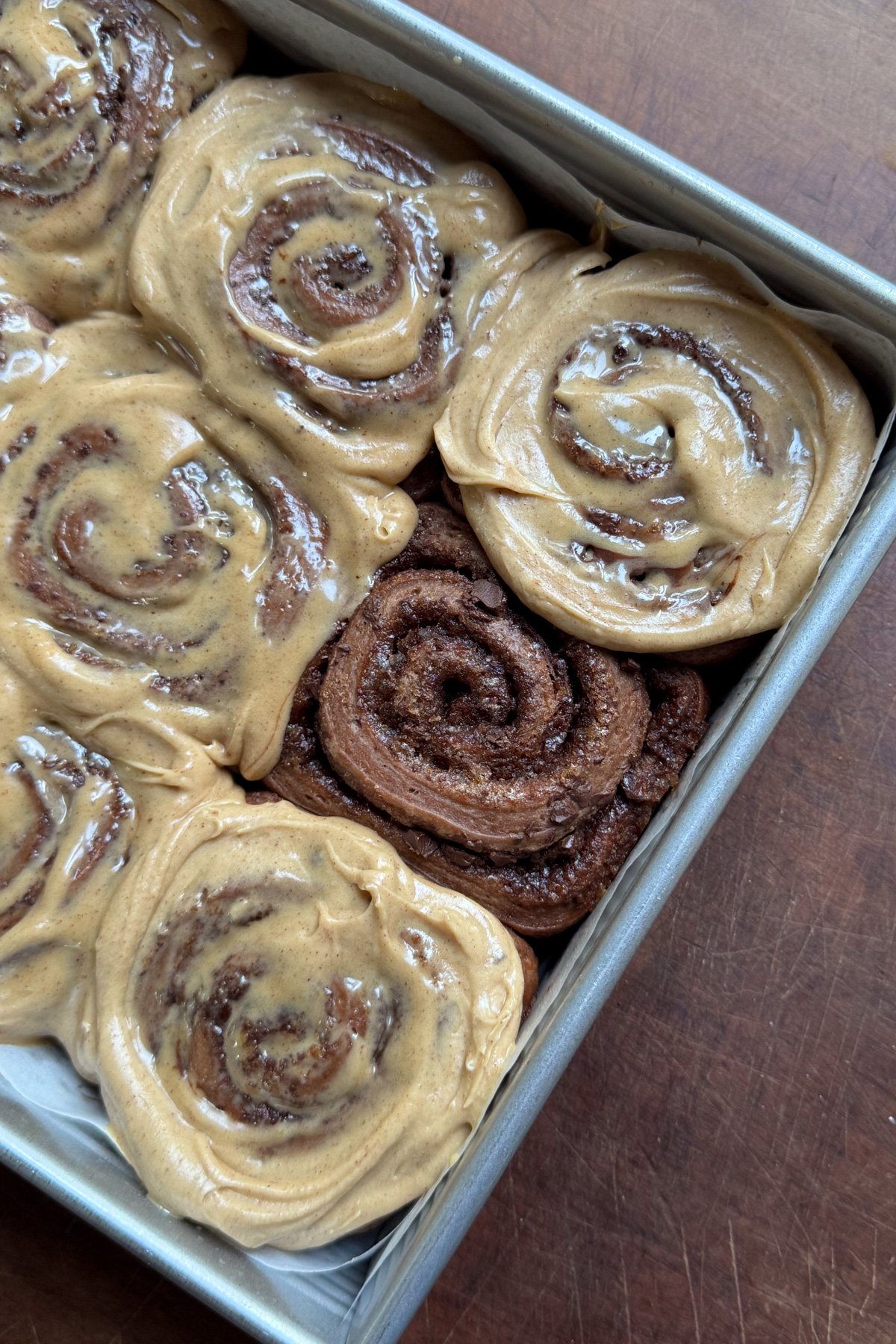 Overhead picture of baked chocolate cinnamon rolls with cinnamon espresso cream cheese icing. 