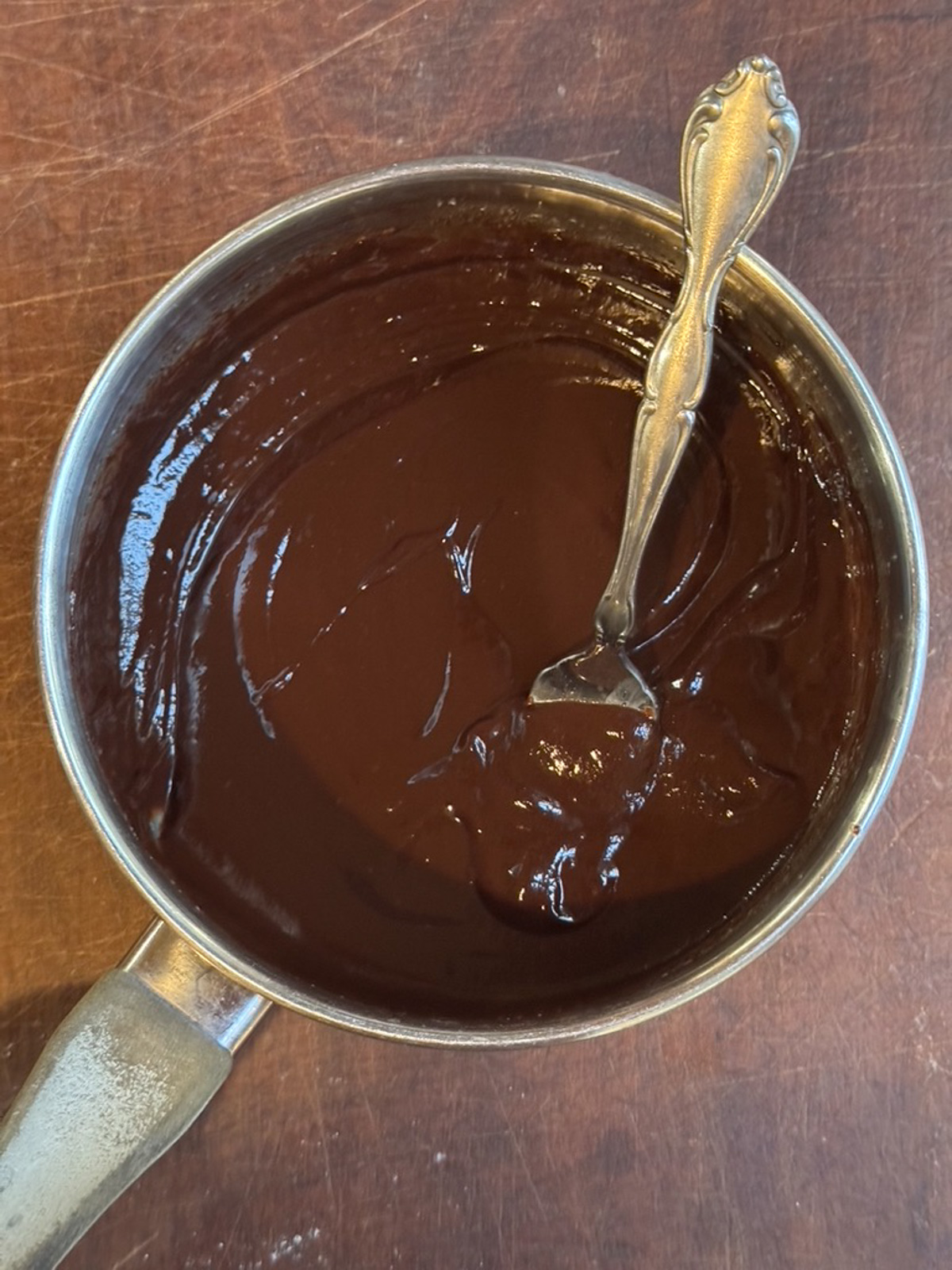 Picture of ganache in a small saucepan for chocolate sour cream pound cake.