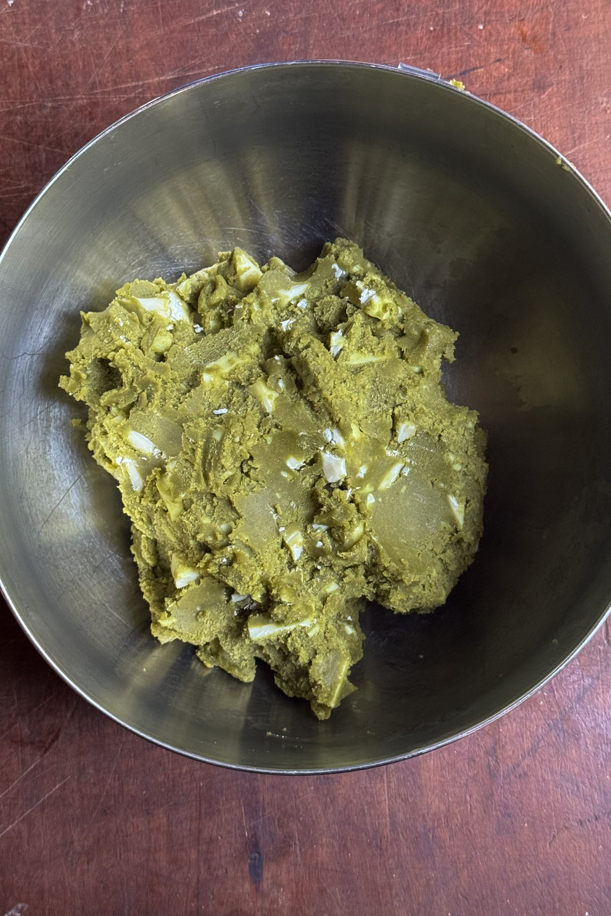 Overhead picture of matcha white chocolate cookie dough in a mixing bowl after being chilled.