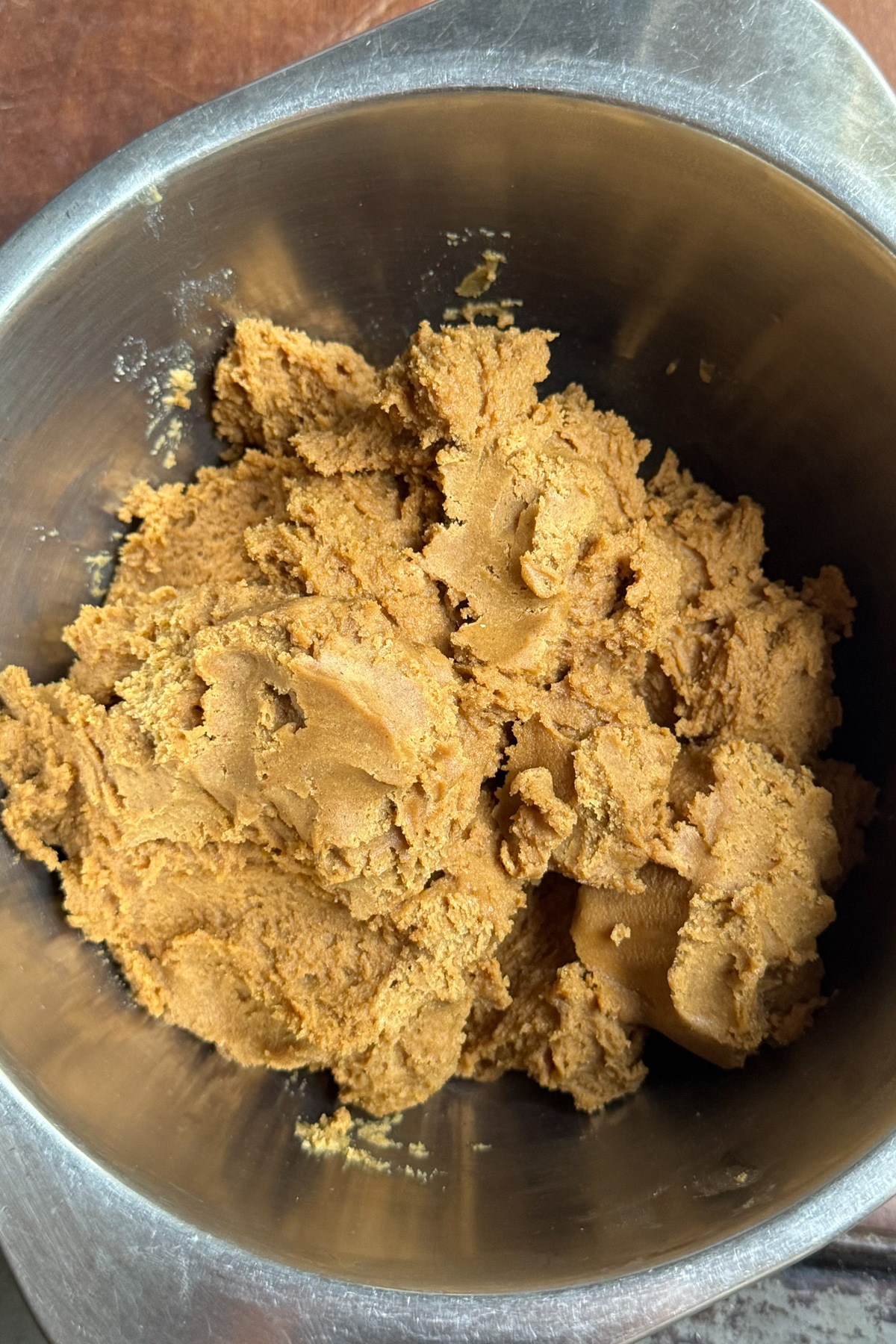 Overhead picture of sourdough gingerbread cookie dough in a metal mixing bowl.