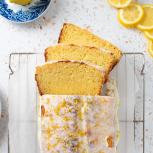 Overhead picutre of sourdough lemon pound cake on a cooling rack with three slices fanned out.
