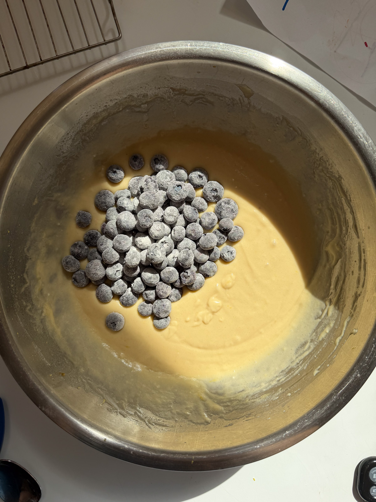 Overhead picture of sourdough blueberry muffin batter with frozen blueberries on top before mixing in.