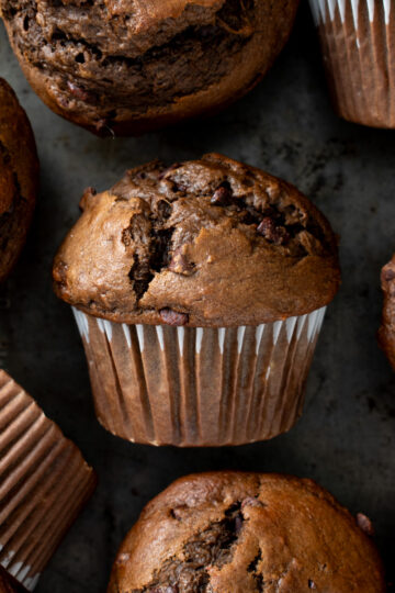 Picture of sourdough chocolate banana muffins on a metal baking sheet.