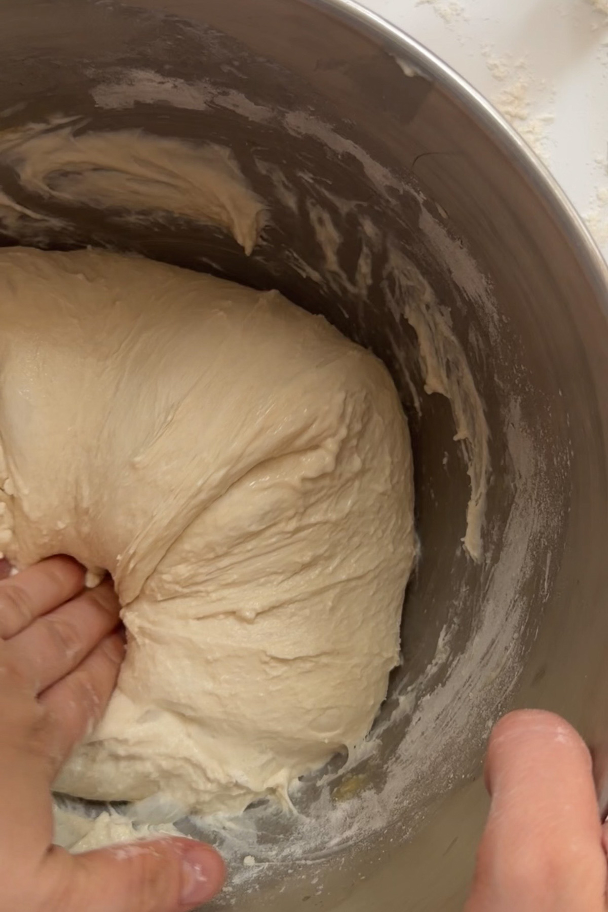 Picture of a hand doing stretch and folds on sourdough discard ciabatta dough.