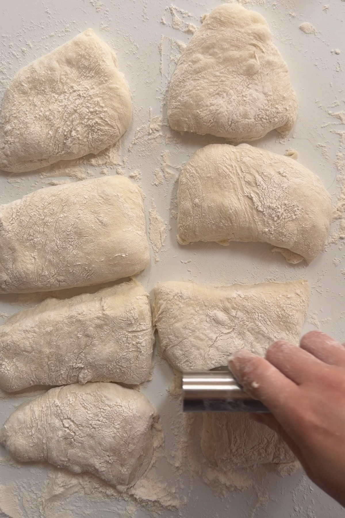 Picture of sourdough discard ciabatta dough being shaped into eight rolls before baking.