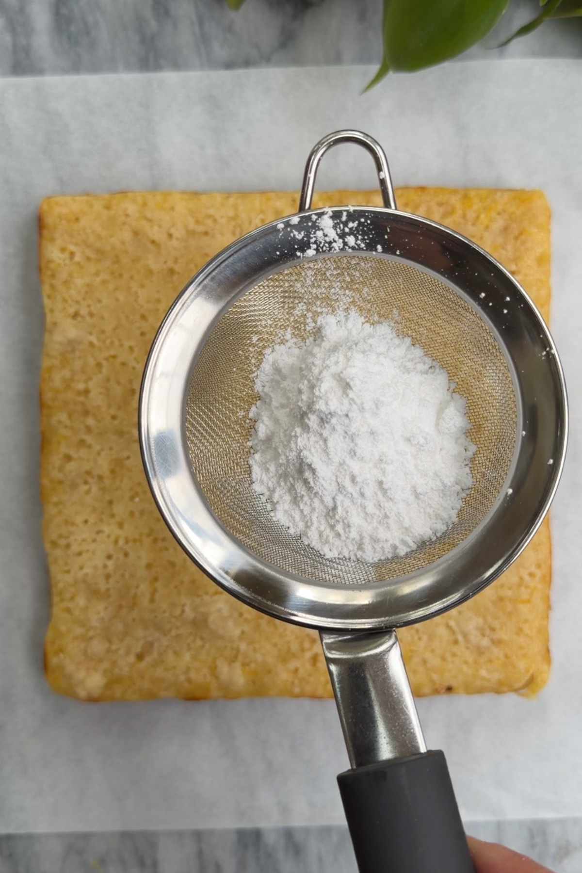 Picture of step 4 of the instructions for lemon crumb bars, showing the baked crumb bars being dusted with powdered sugar.