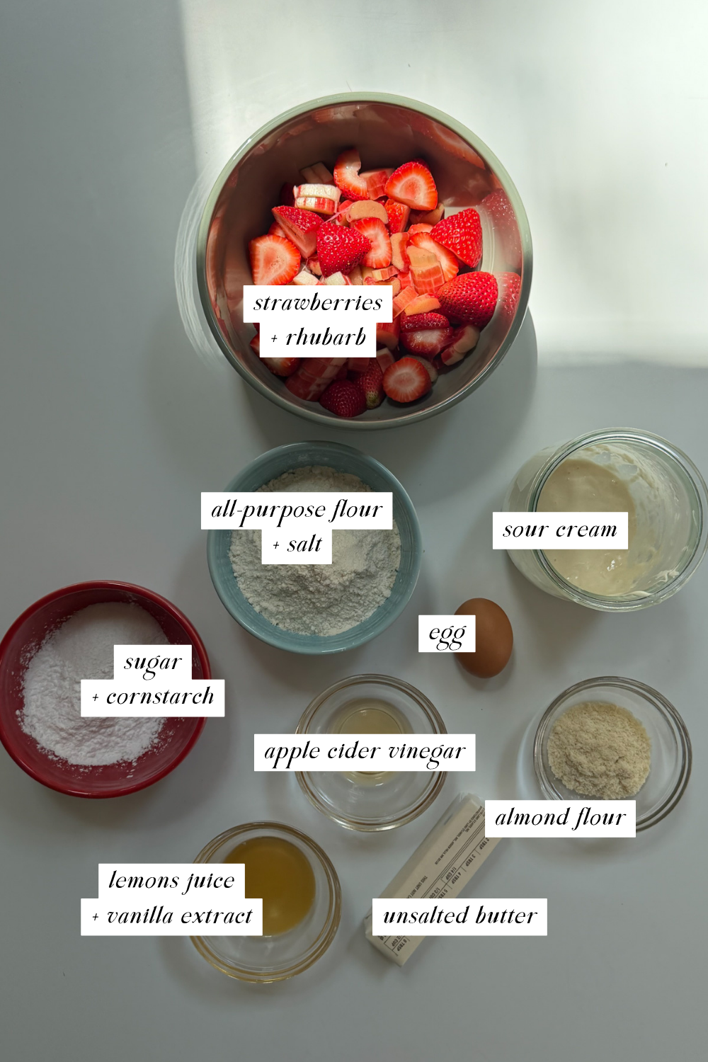 Overhead image of the ingredients needed for a strawberry rhubarb galette with ingredient labels.
