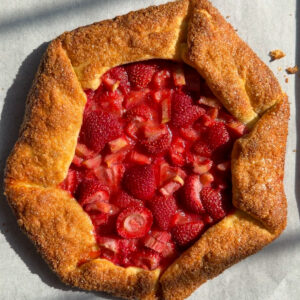 Strawberry rhubarb galette on a parchment paper-lined baking sheet.