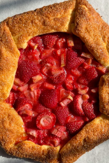 Strawberry rhubarb galette on a parchment paper-lined baking sheet.