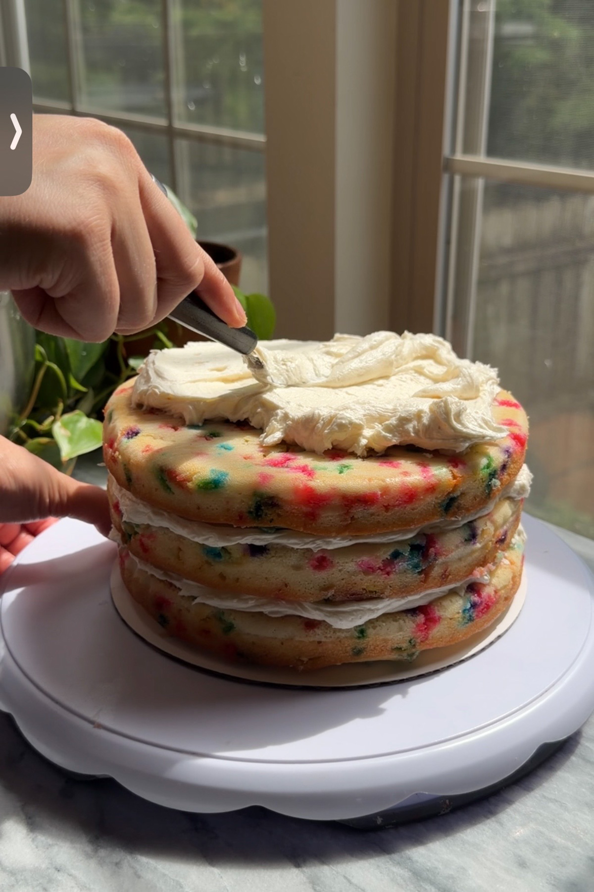 sourdough discard funfetti birthday cake being decorated.