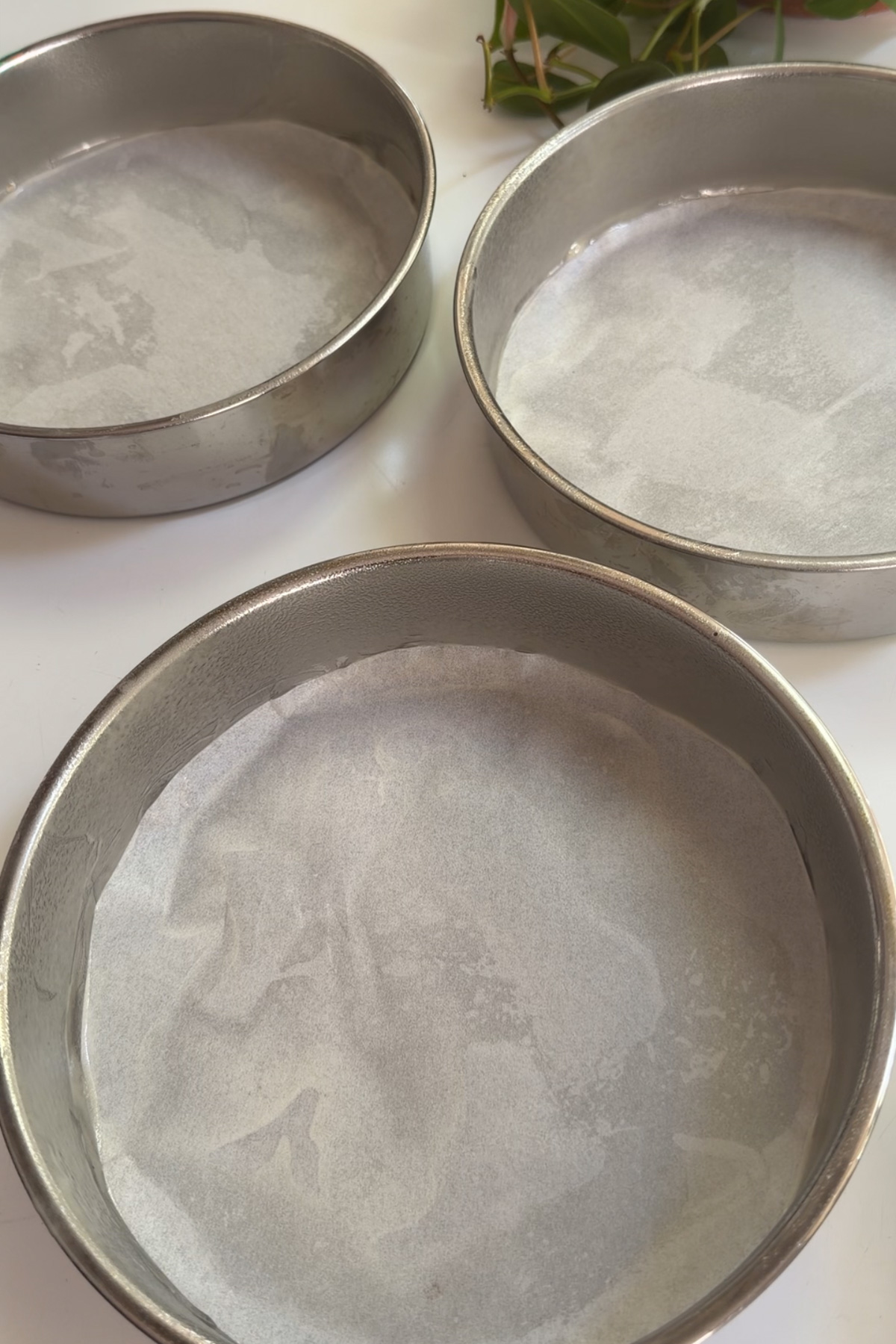 Greased and lined 8-inch pans for strawberry cake with strawberry filling.