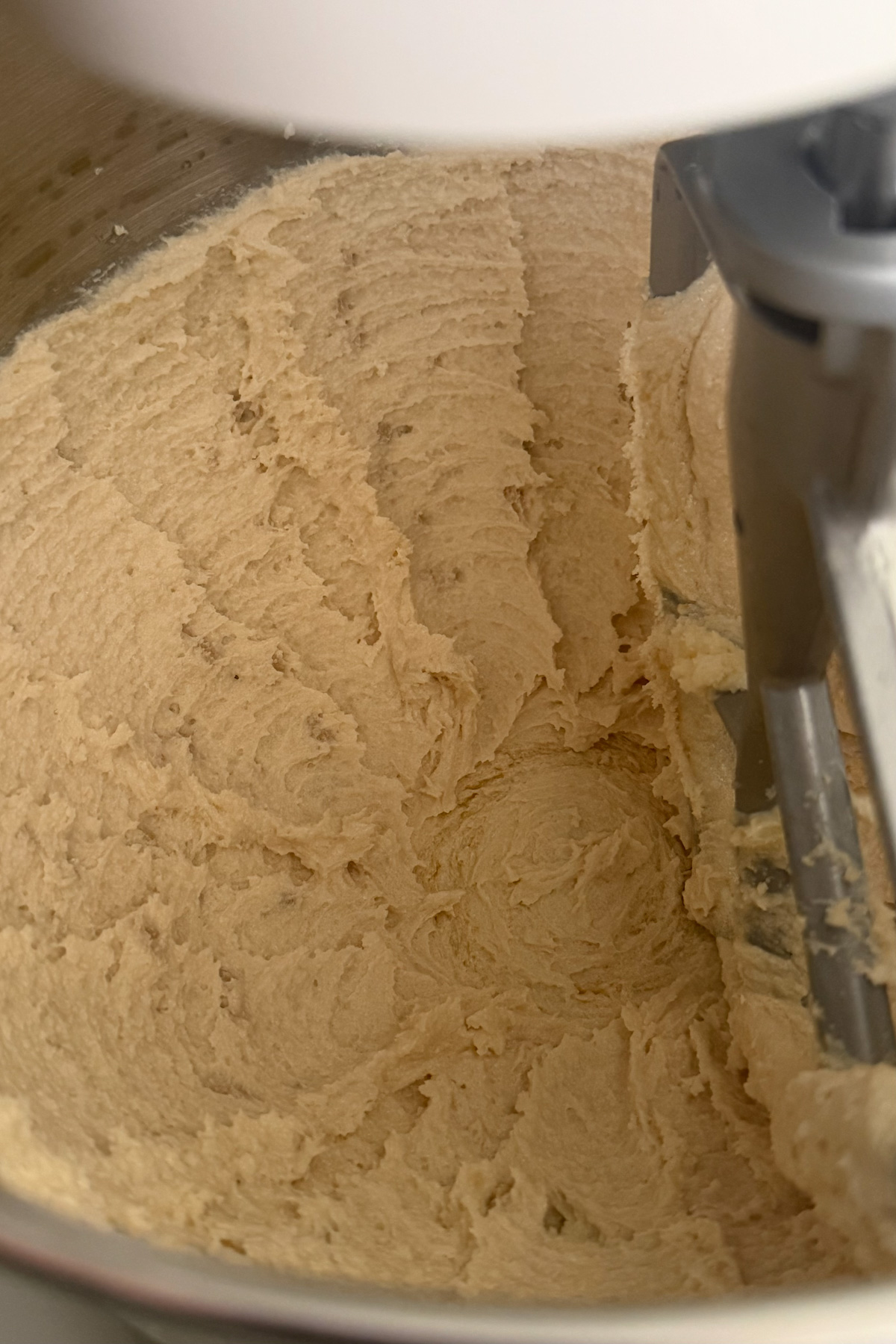 Whipped butter and sugar for apple butter snickerdoodle cookies in a stainless steel mixing bowl.