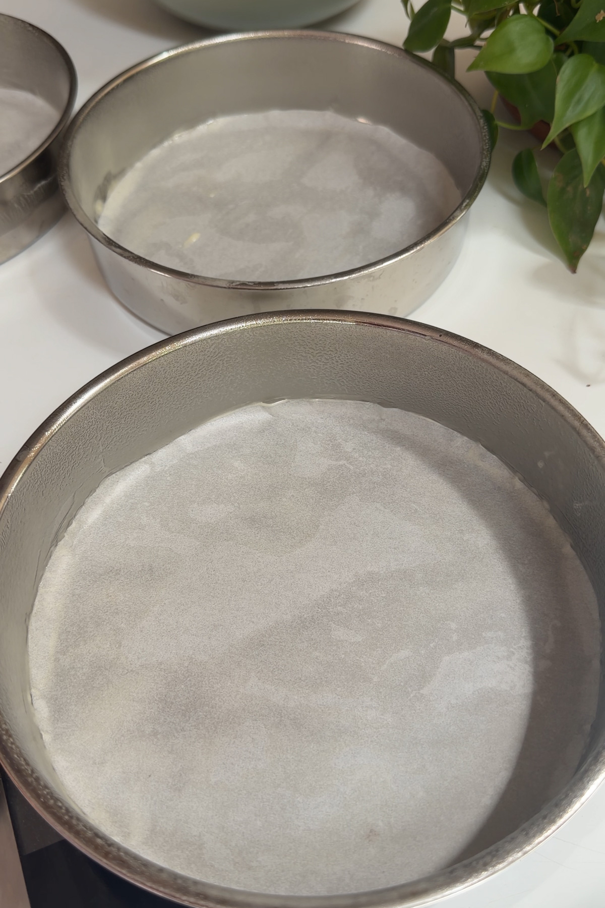 Prepped 8-inch cake pans for a dark chocolate raspberry layer cake.