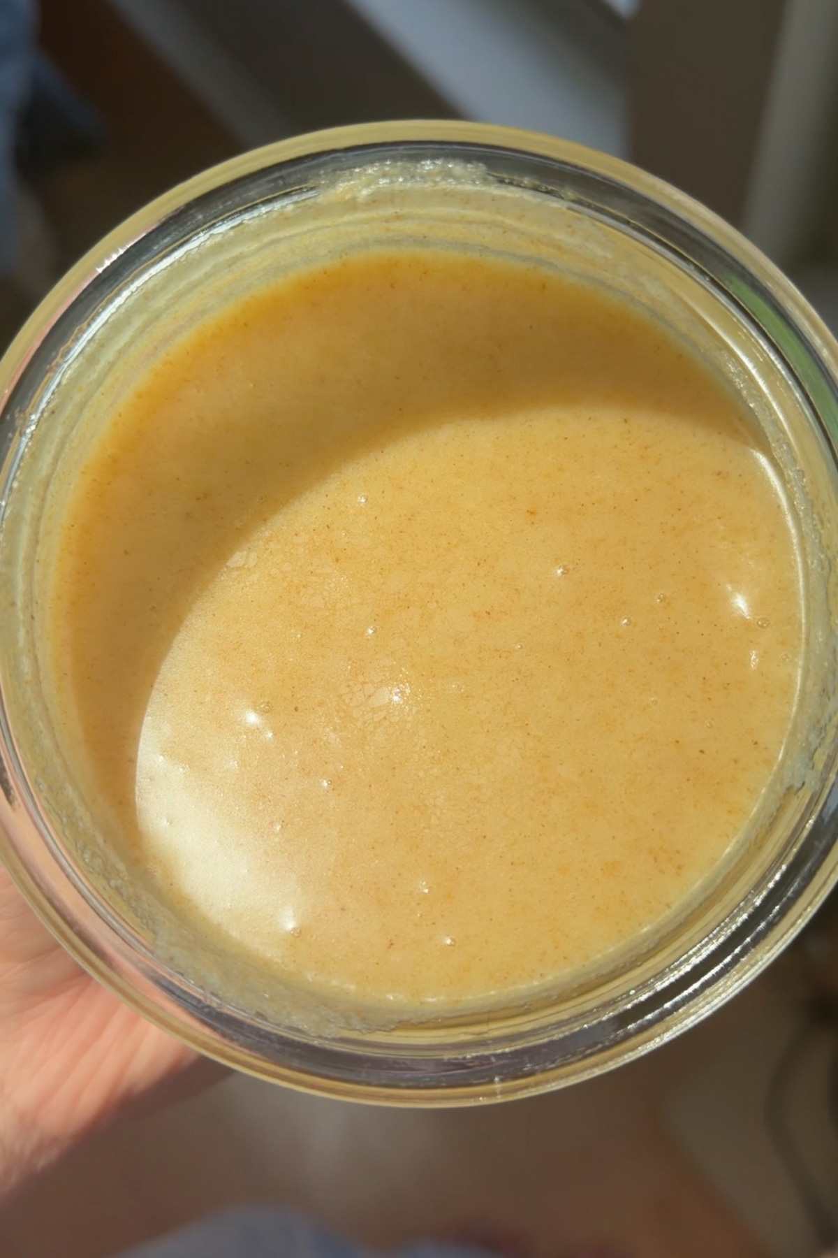 A picture of cooled brown butter in a glass bowl for brown butter bourbon peaches and cream cake.