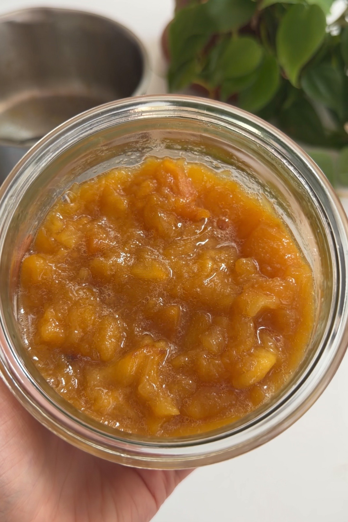 A picture of cooled peach compote in a glass bowl for brown butter bourbon peaches and cream cake.