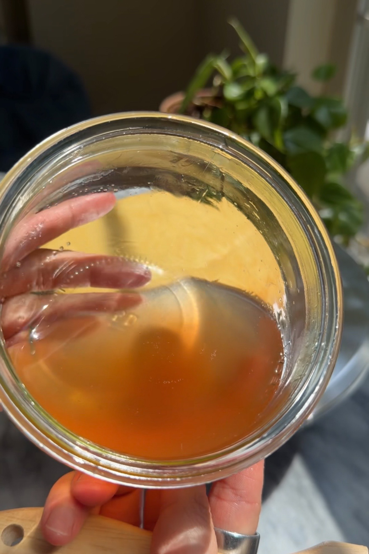 A picture of cooled peach syrup in a glass bowl for brown butter bourbon peaches and cream cake.