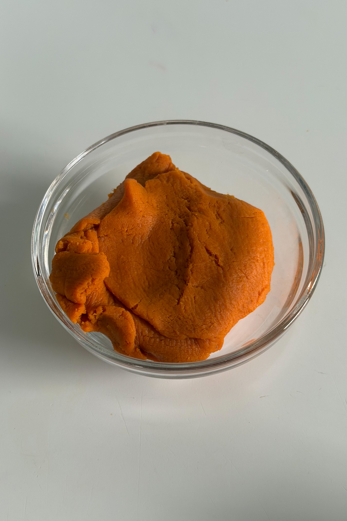 Blotted pumpkin puree in a glass bowl for cinnamon sugar pumpkin blondies.