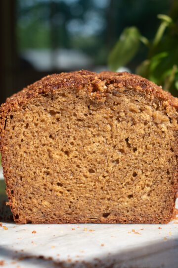 Apple butter banana bread sliced on a marble countertop to show a soft, tight crumb.