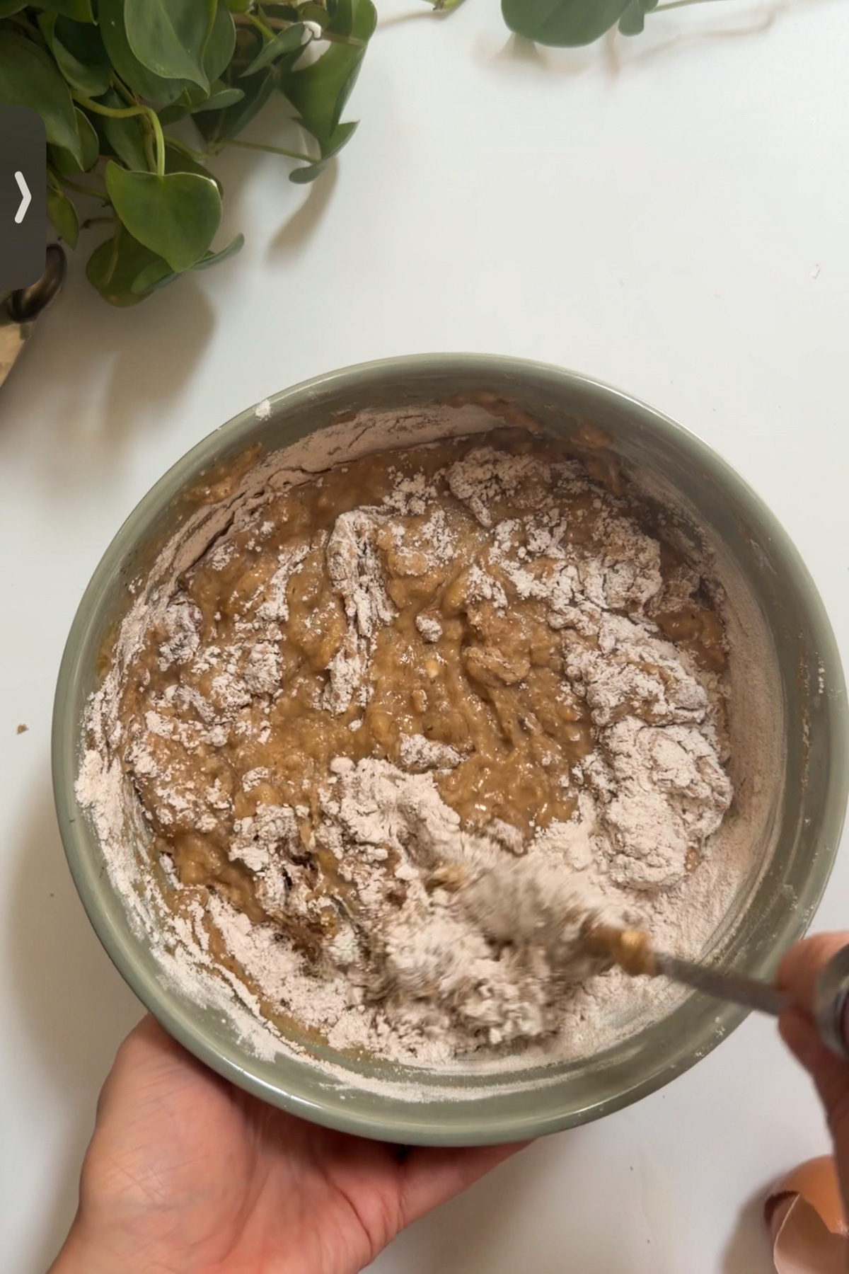 The making of the batter for apple butter banana bread in a green mixing bowl.