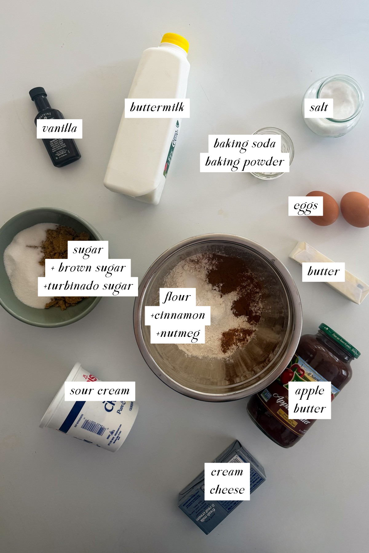 The ingredients needed for cheesecake-stuffed apple butter muffins with labels.