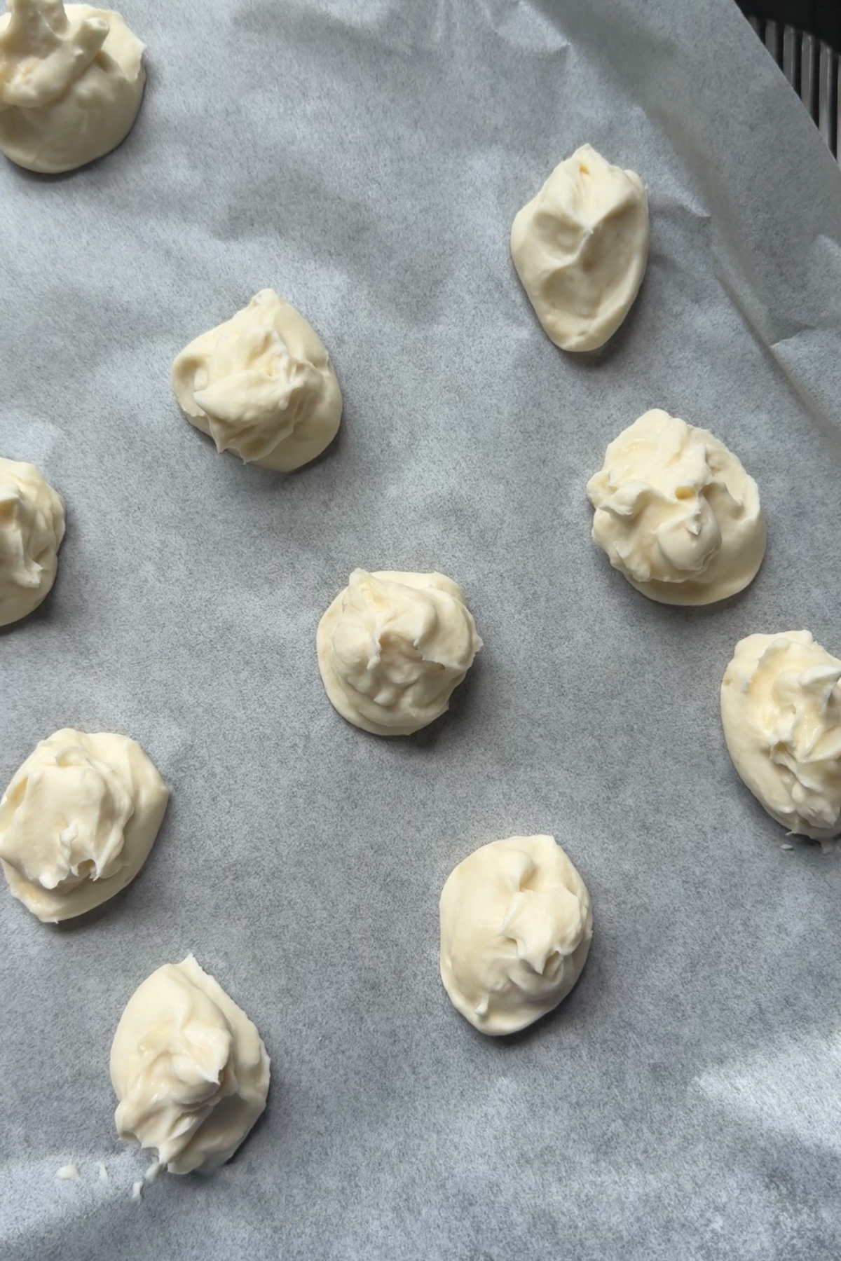 Frozen cheesecake balls on a baking sheet to be added to the batter of the cheesecake-stuffed apple butter muffins.