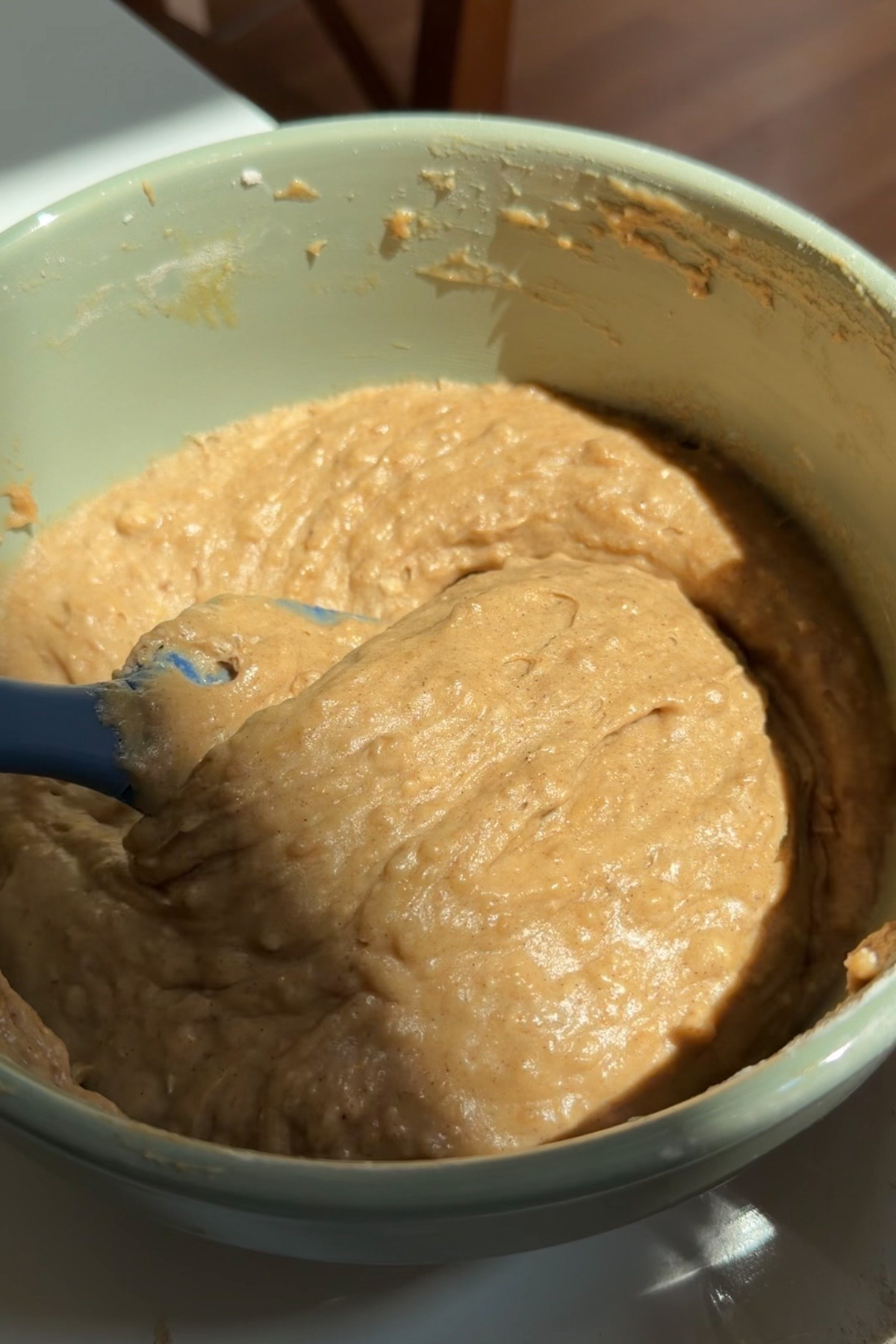 The batter for cheesecake -stuffed apple butter muffins in a green mixing bowl.