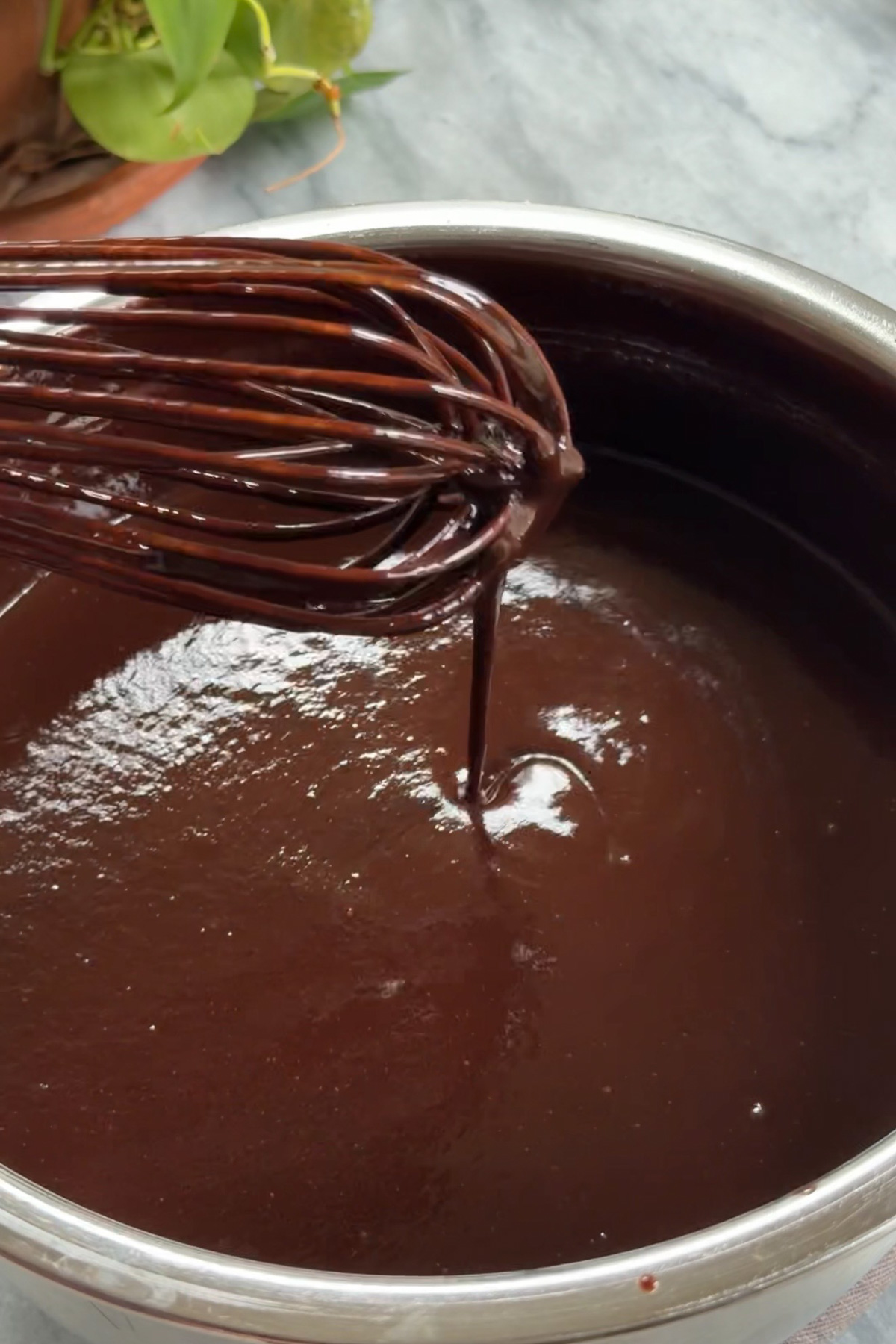 The fudgy chocolate ganache frosting for Matilda's Chocolate Cake in a mixing bowl before cooling.