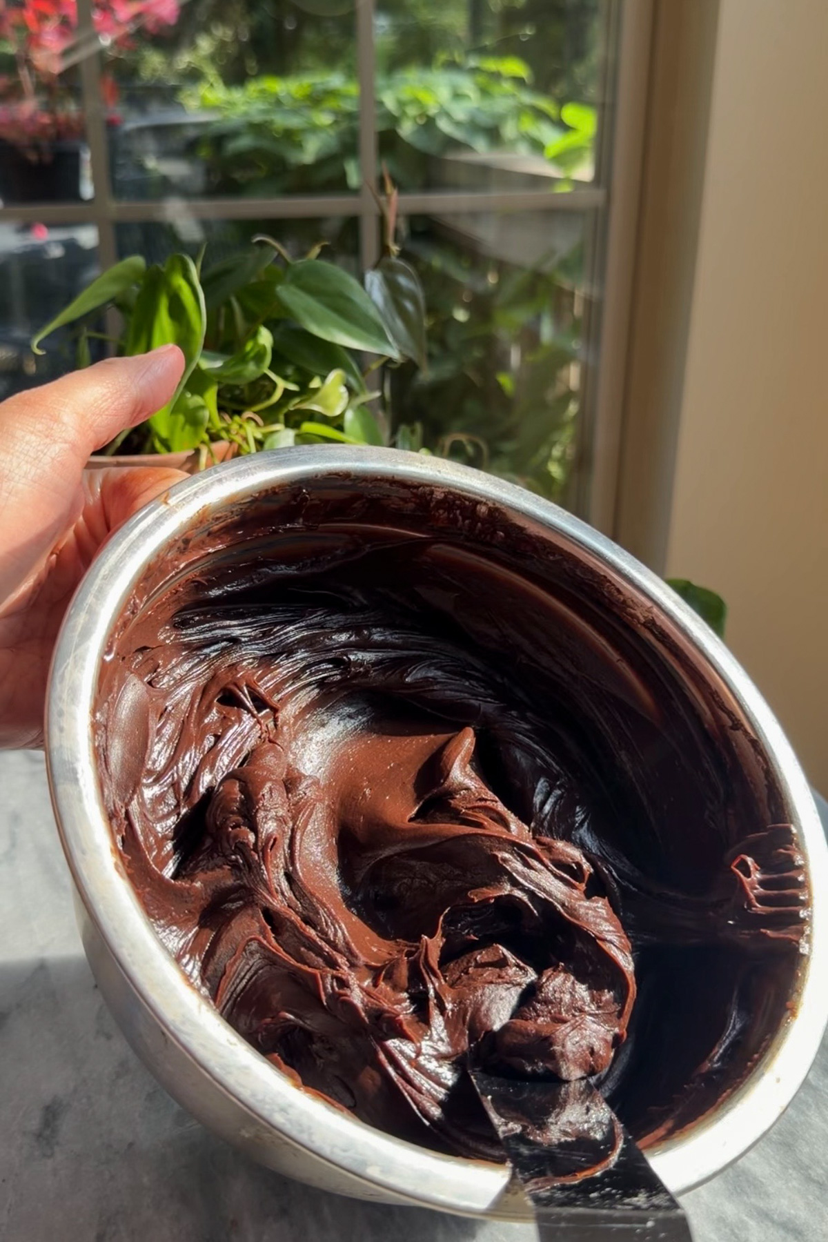 The fudgy chocolate ganache frosting for Matilda's Chocolate Cake in a mixing bowl after cooling.