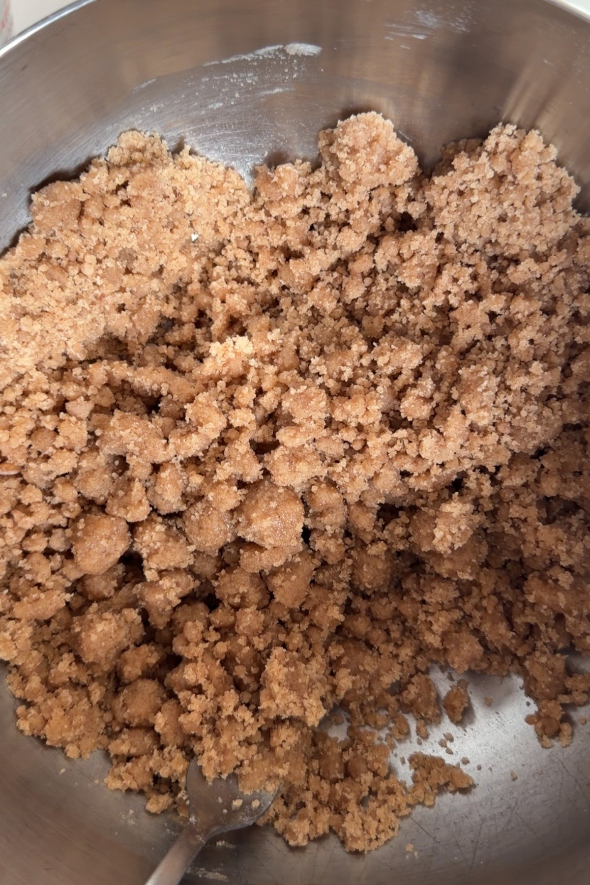 Cinnamon streusel in a stainless steel mixing bowl before being added to pumpkin coffee cake.