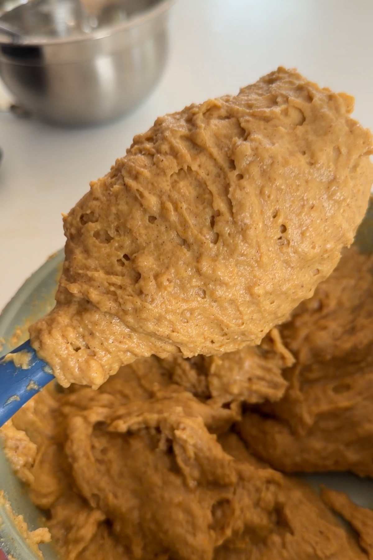 Pumpkin coffee cake batter on a silicone spoon.