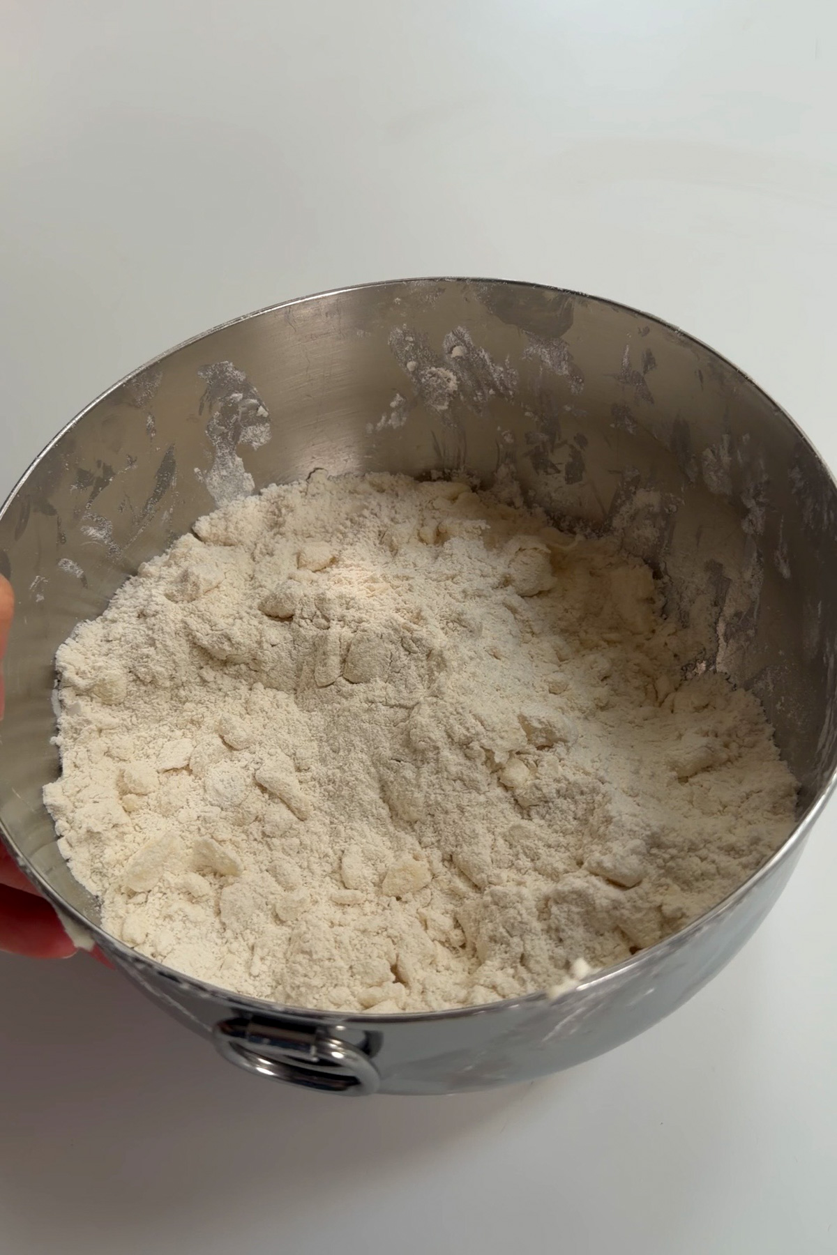 The dry ingredients for sourdough discard biscuits in a metal mixing bowl on a white countertop.