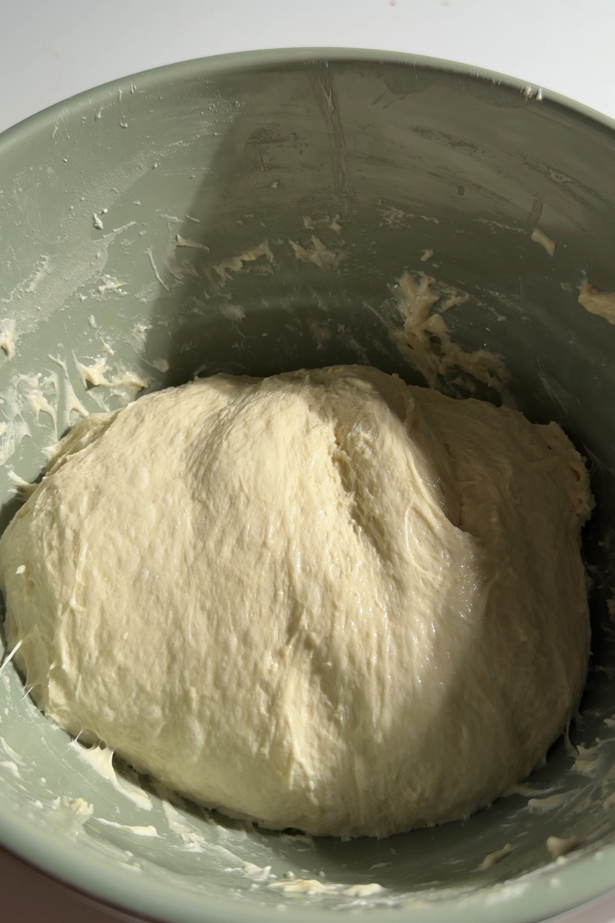 Sourdough discard focaccia bread dough in a green mixing bowl at the start of the first rise.