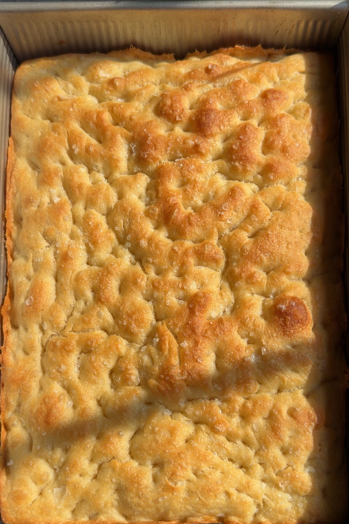 Sourdough discard focaccia bread in a 9x13 pan after coming out of the oven.