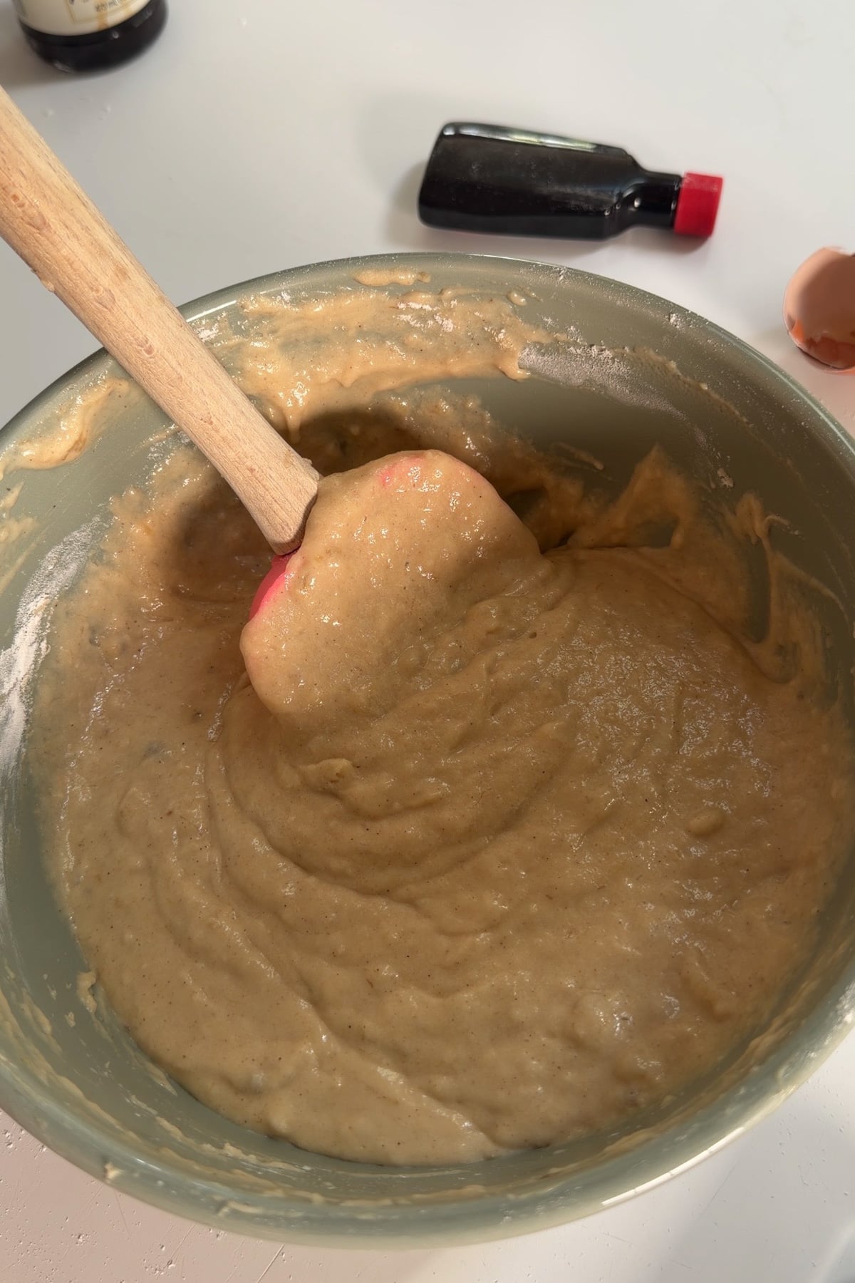 Banana bread muffin batter for banana blueberry muffins in a green mixing bowl.