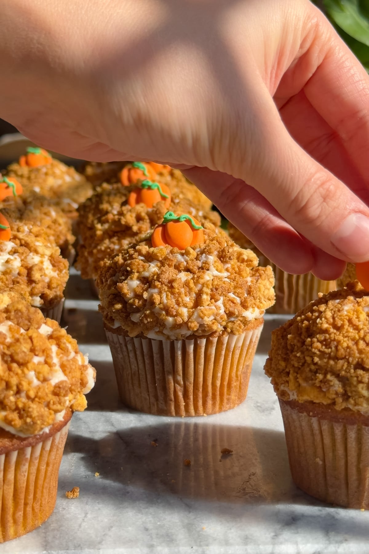 Pumpkin crunch cupcakes coated in Golden Oreo crumble and topped with pumpkin decorations.