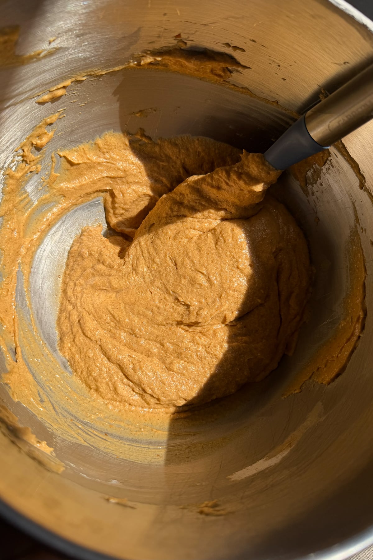 Pumpkin crunch cupcake batter in a stainless steel mixing bowl.