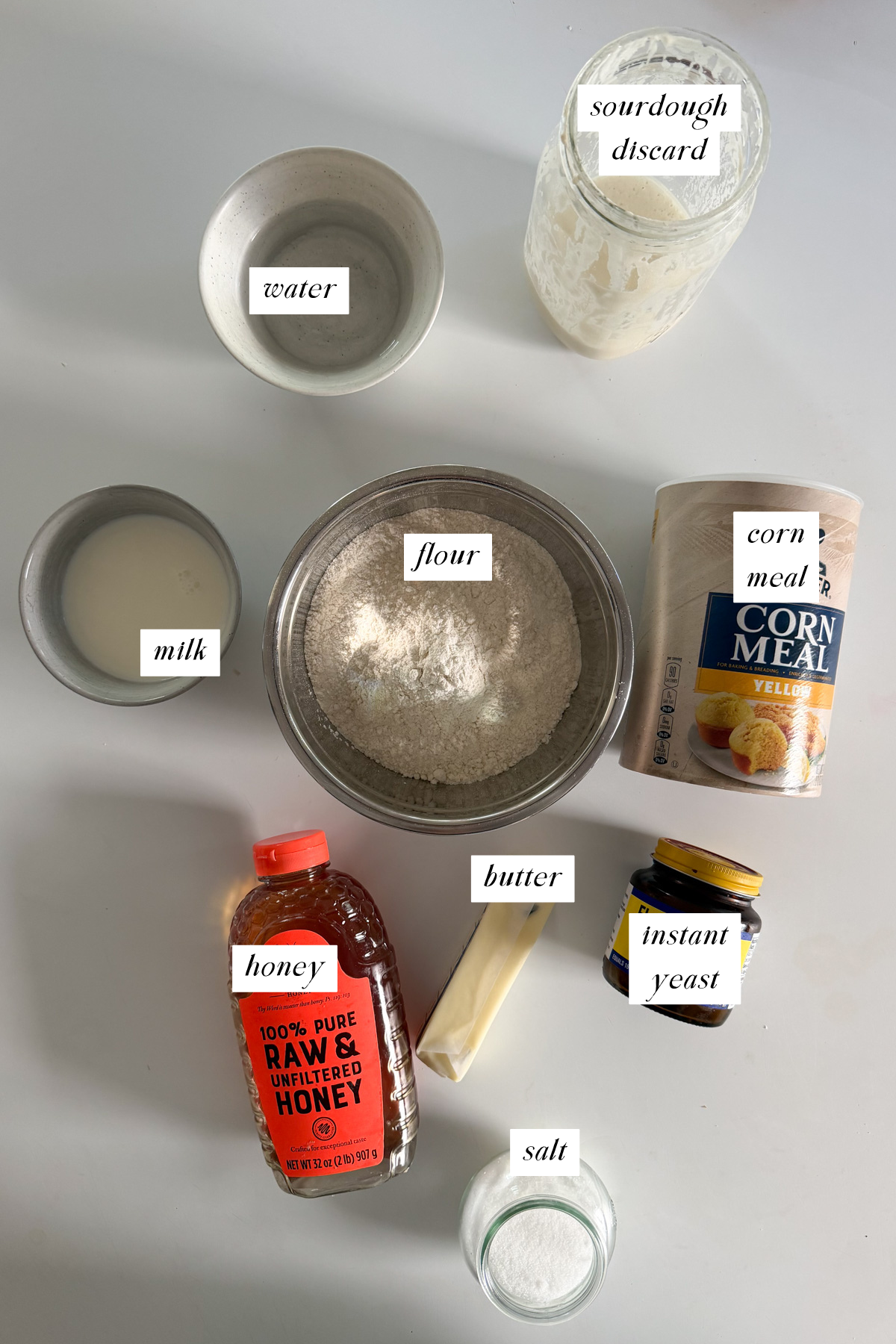 The ingredients needed for sourdough discard English muffins with labels.