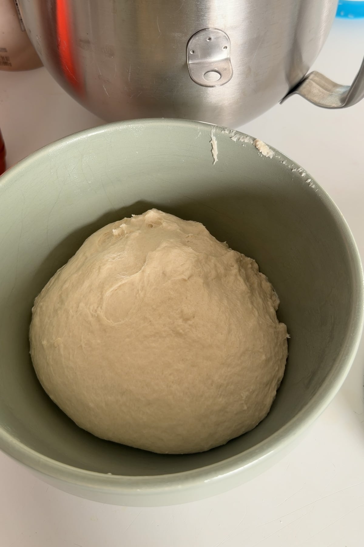 The dough for sourdough discard English muffins in a green mixing bowl before the first rise.